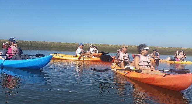 Kayakers on an eco tour pause for notes on local birdlife from a guide - Photo Abbie Beltran