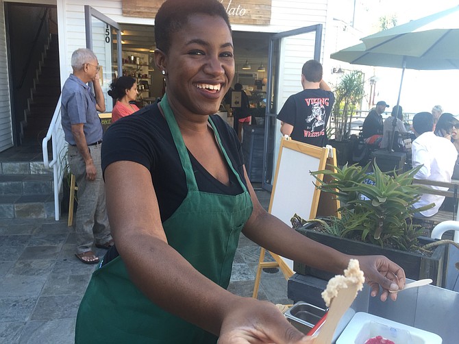 An employee of Bobboi offers sample of the Blood Orange sorbet to passers-by