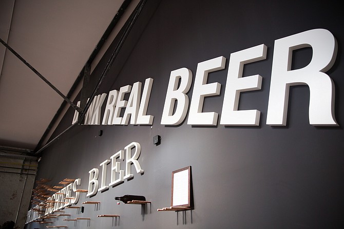 The wall of Stone Brewing Berlin's new Library Bar says "Drink real beer" in both German and English.
