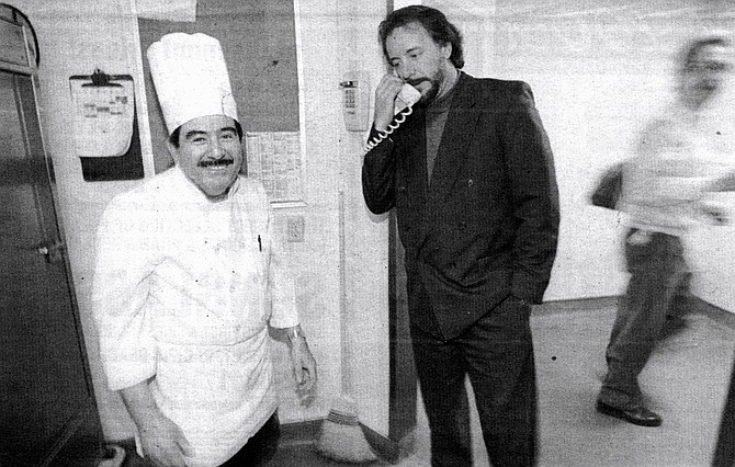 Chef William Rivera (left) and Jef Eatchel (center) on phone.  "For a lot of these people, this is their main meal, and it's usually two: one before or after your shift, one on your break." - Image by Sandy Huffaker, Jr.