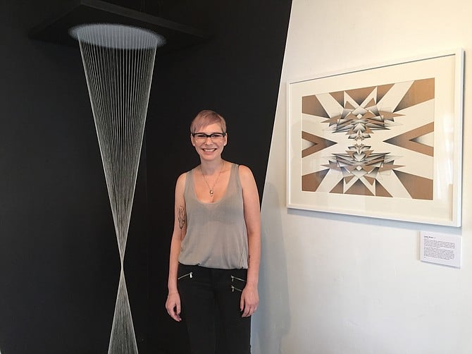 Artist Melissa Walter with two of her works, an installation piece and a pen and ink drawing. 
