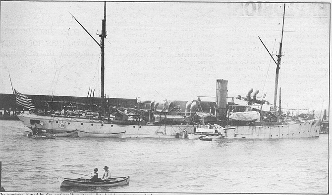 The gunboat, gutted by fire and scalding steam, lists beside a downtown dock. The sudden influx of sea water increased the list to starboard and alarmed Gauthier and the other sailors who had survived the blast but were trapped in compartments of the ship.