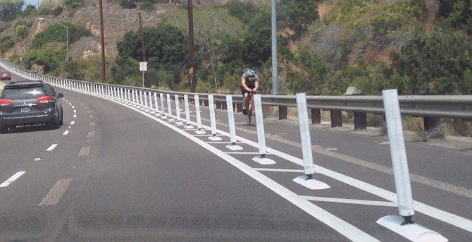 Cyclist headed toward Clairemont Drive behind the new barriers.