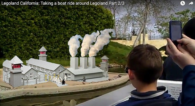 Screenshot of YouTube video taken by passengers aboard the Legoland California river cruise as it passes the newly controversial model of the Auschwitz concentration camp. “I can remember when passengers would ooh and aah over the ‘smoke' billowing out of the stacks above the crematorium,” says guide Zeno Weevil. “And it’s really amazing just how many Holocaust jokes people are able to remember and share. But ever since that clown movie hit the internet, the boat just gets really quiet until from here until we reach the New Orleans jazz band with an octopus on the drums. Then they perk back up.”
