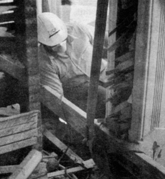 A workerman disassembles the original hotel. The building was demolished and every salvageable piece of brick, mortar, and bric-a-brac carefully cataloged and stored.