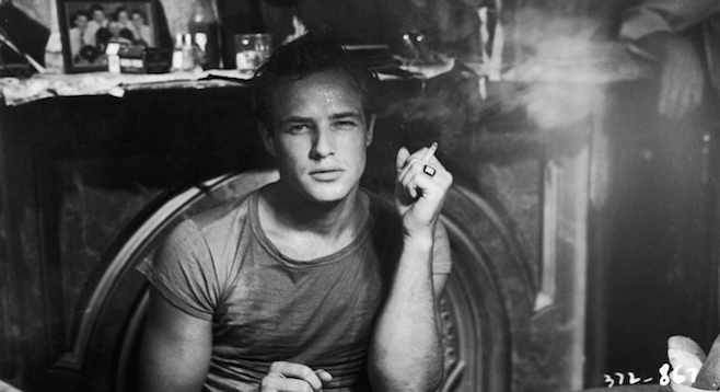 Marlon Brando grabbing a smoke between takes on the set of A Streetcar Named Desire.