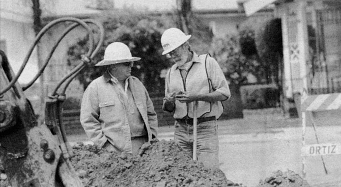 Larry Pierson (left), archeologist, and George Kennedy, paleontologist, examine a rock specimen - Image by Sandy Huffaker, Jr.