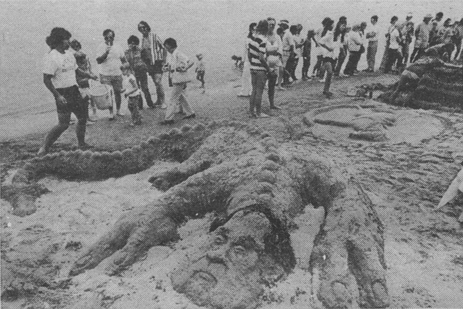 Beachgoers make a sand sculpture of former president Richard Nixon as a lizard - Image by Bob Eckert
