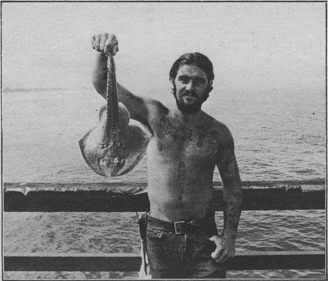 A fisherman displaying a flatfish he caught - Image by Bob Eckert