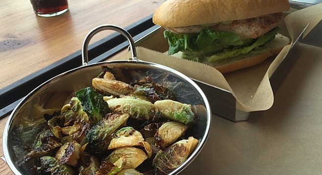 Brussels sprouts and a large breast tucked inside two halves of a ciabatta bun
