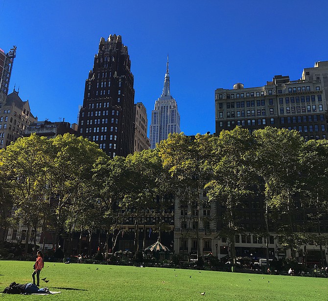 View of the Empire State Building (silver) and American Radiator Building (black and gold) from Bryant Park, Manhattan, New York City.  It's art deco architecture in the park!  9/16
