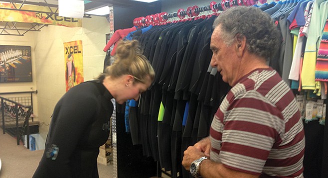 John Buono helps a customer try on a suit at South Coast