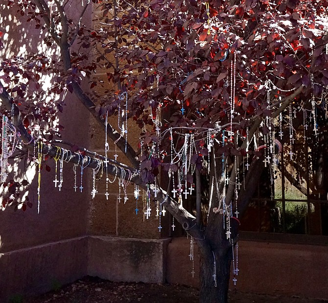 Rosary Beads hung by visitors on a tree outside of Loretto Chapel