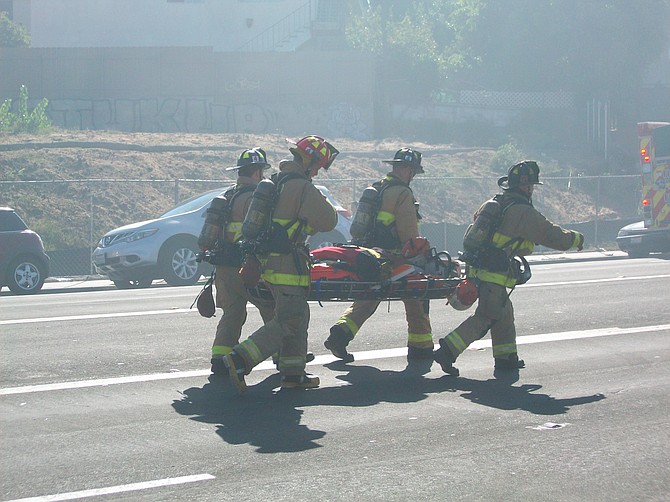 Firemen respond to an injured comrade in Midway District.
