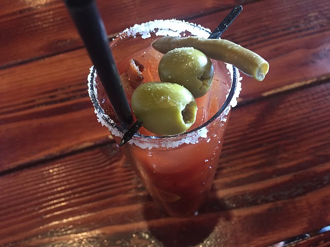 The Hills' bloody mary is spicy, tangy and comes with bacon, blue cheese-stuffed olives, and a pickled green bean.