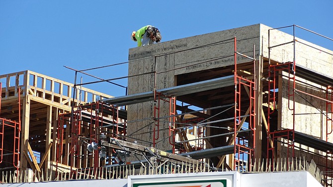 A construction worker on top of the Eitol apartment complex being built on University Avenue in Hillcrest.