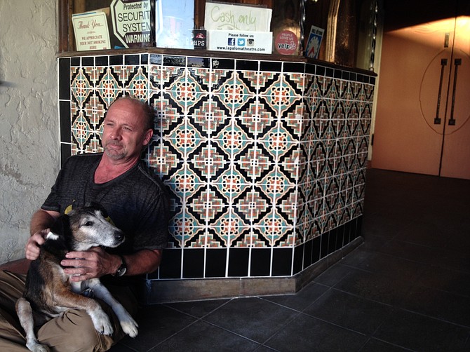 Theater owner Alan Largent and his dog Oscar leaned up against the ticket booth