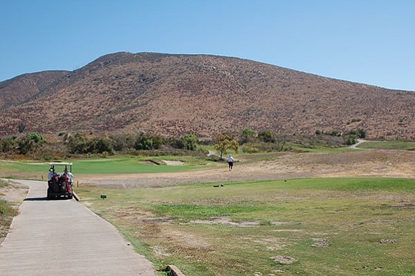Golfer traverses a “forced carry” looking for his ball. Mt. Miguel frowns in the background.