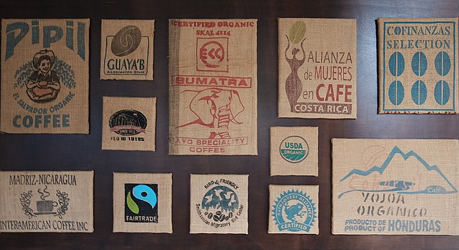 A collage of burlap coffee bags hangs in Cafe Virtuoso’s updated Barrio Logan coffee shop