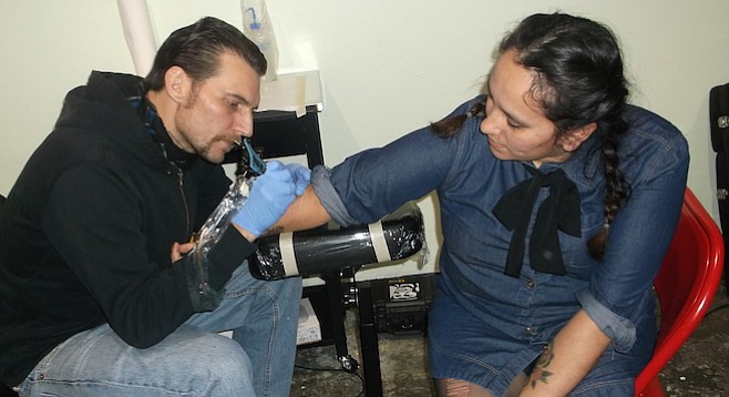“It’s kind of become a tradition for us,” Kat said, wincing as tattoo artist Jordae worked on her right arm.