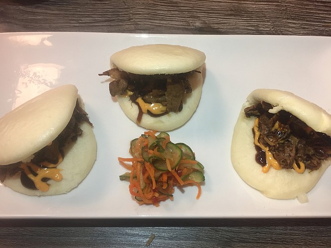 Bao Bun Tacos come with brisket and pickled vegetables with hoisin sauce.