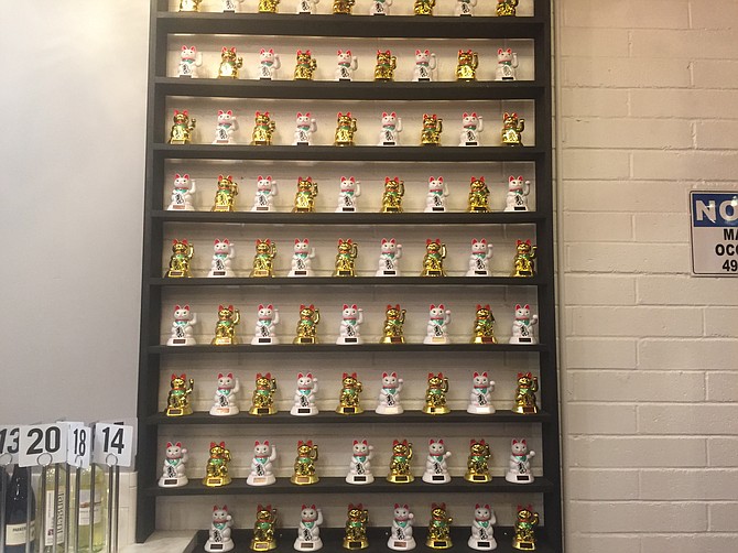 The entrance to Blvd Noodles features a wall of lucky cats.
