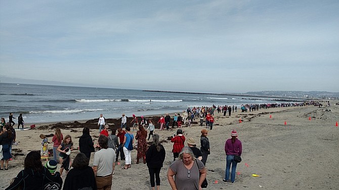 The group marched from Dog Beach to in front of the pier, where they spelled out their demand.