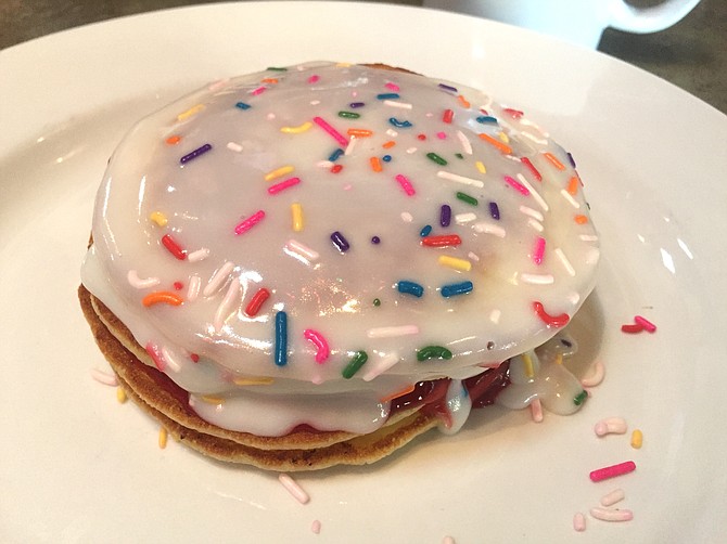 Homer Cakes: a stack of pancakes with jelly between each one, topped with glaze and sprinkles