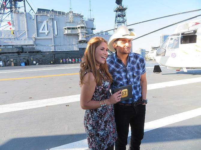 Entertainment Tonight Host Sophie Schillaci poses with Brad Paisley on the flight deck of the USS Midway (Photo by Patty Mooney