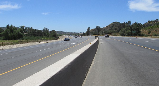 The curvy road was only 28 feet wide. The widened highway is now 88 feet wide; wider at intersections.