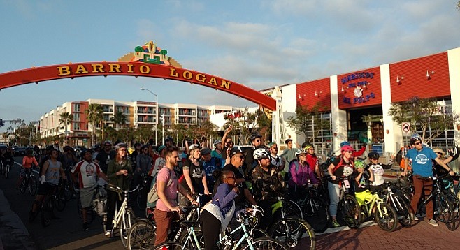 Bike enthusiasts gather under Barrio Logan's gateway sign