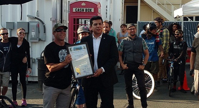 City Councilmember David Alvarez presents Bike Coalition executive director Andy Hanshaw with an award and proclamation of May as Bike Month in San Diego