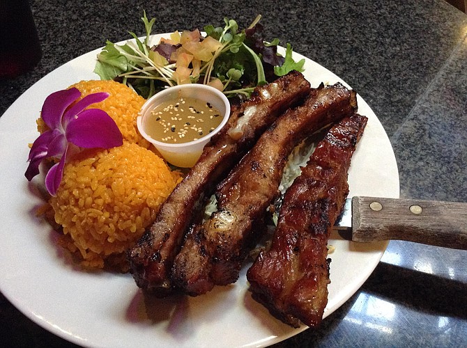 Uncle Frank's pork ribs, with achiote-stained rice and salad