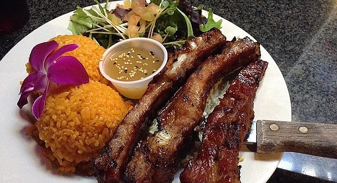 Uncle Frank's pork ribs, with achiote-stained rice and salad. The first thing you notice is the orchid. 