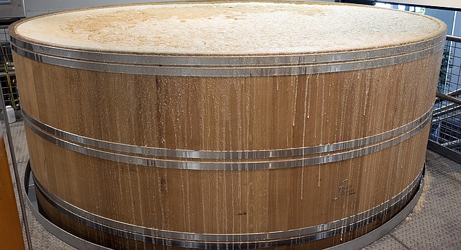 An oak foudre threatens to overflow with mashed grain fermenting for whiskey production