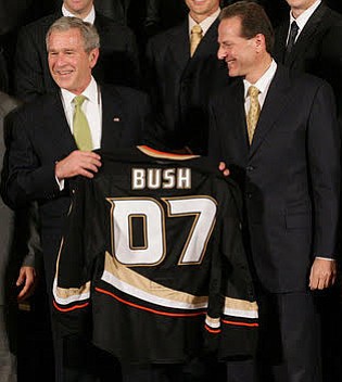 Samueli (right) and the Stanley Cup champion Anaheim Ducks present then-President George W. Bush with a jersey.