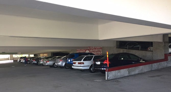 Parking garage. The female saw the man hiding by the front bumper of her vehicle.