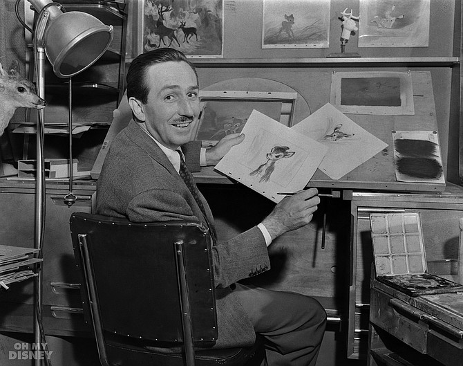 Walt Disney showing sketches from Bambi.