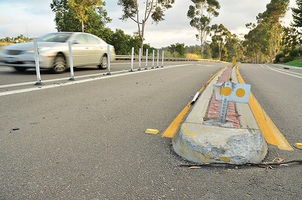 White plastic bollards (left) at Pomerado Road and Caminito Alto