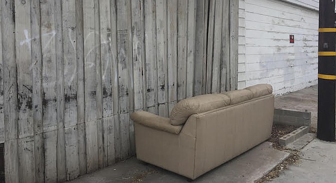 After four days, a leather couch still remains in her back alley.