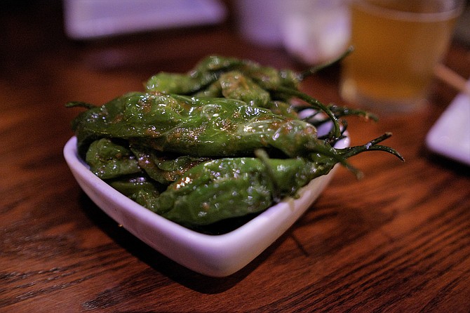Shishito peppers are roasted to reduce spice slightly and then slathered in garlic paste.