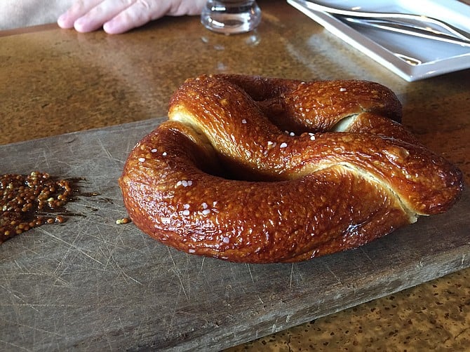 Bavarian pretzel, served with cheese fondue and mustard seed.