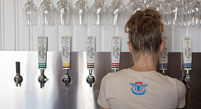 A Modern Times employee pours beer in its Point Loma tasting room.