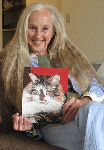 Jill holding a portrait of a cat named Cloud who is no longer living. 20% of her clients want portraits of pets that have crossed over the 'Rainbow Bridge.' 