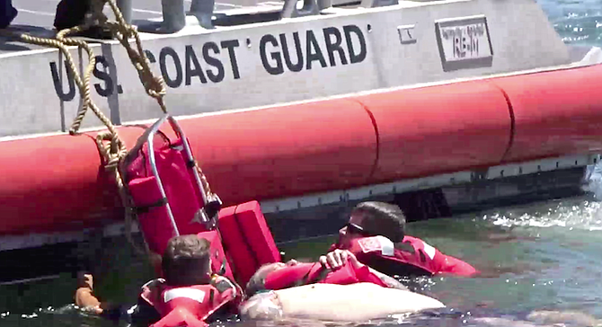 Coast Guard managed with much difficulty to get him onto a stretcher and pulled up on to the back of their boat.