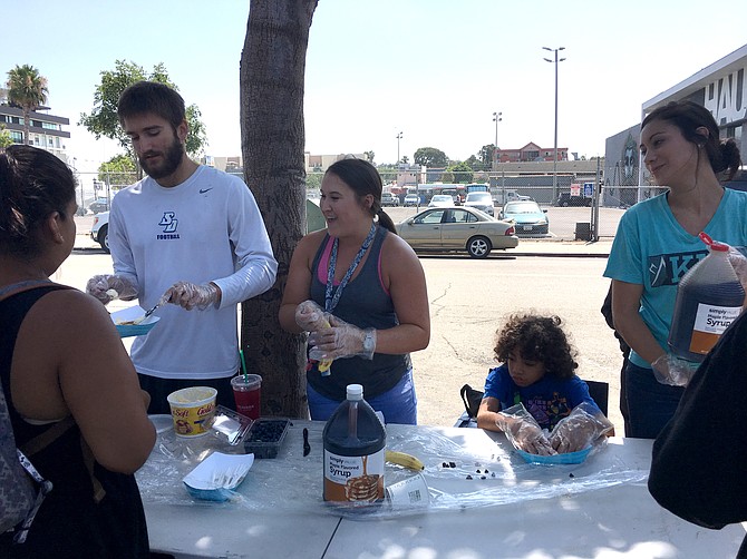 Amory Fratoni, Aya Healthcare payroll coordinator, serves pancakes to the homeless community in downtown San Diego. To learn more, visit: https://goo.gl/nEHTAH.
