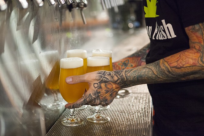 An employee pours Green Flash beer