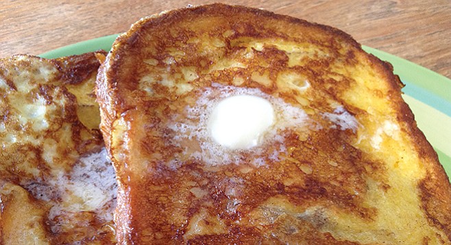 French toast is fully inch-thick, drowning in butter.
