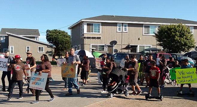 Rafael Bautista (left, red cap) leading Village Apartments tenants and activists on a march, September 29