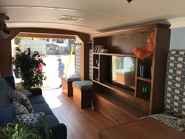 The inside of the Big Shaker is designed like a home, with a big-screen television, shelves with loose items, and benches along the sides.